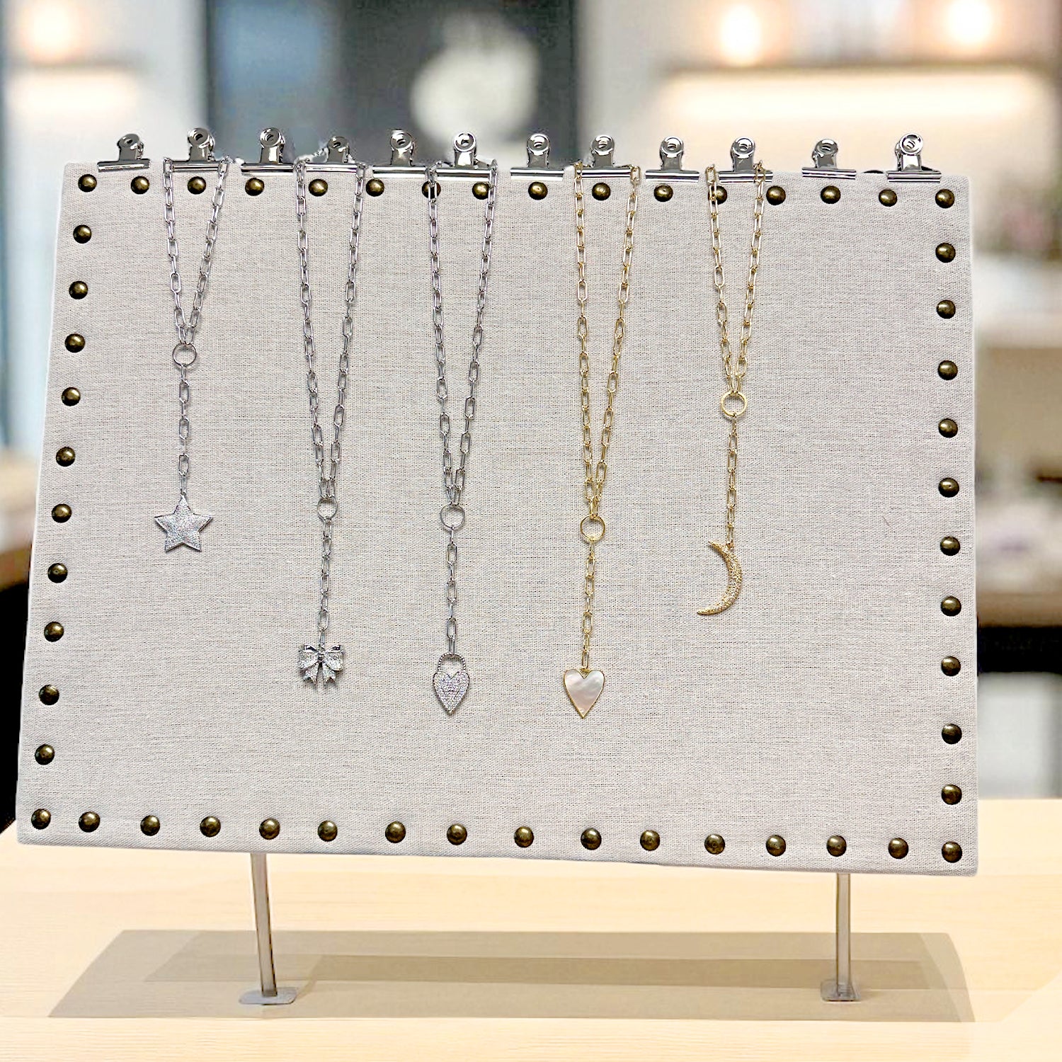 Jewelry display stand with necklaces on a blurred background