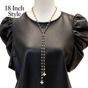 ove Lisa Vittoria 18-inch Y Necklace worn at the neckline with evil eye beads, two dangling strands, and howlite quatrefoil drops