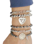 Stack o fWings & Wishes Dime Bracelet with angel wing and dime charm in gold, silver, and gunmetal

