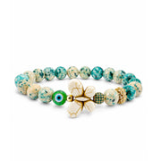 Wish & Wonder Butterfly Sea Sediment Jasper Bracelet in Luck with green beads, white howlite butterfly, green evil eye bead, pavé crystal bead, and gold-tone crystal flower accent bead