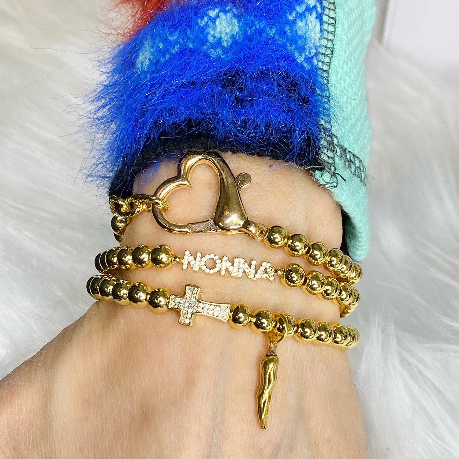 love lisa christine italian horn cornicello cross bracelet lifestyle photo gold style stacked with other bracelets including nonna bracelet