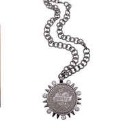 flat lay of black chain necklace with heavy LOVE coin pendant and spike details