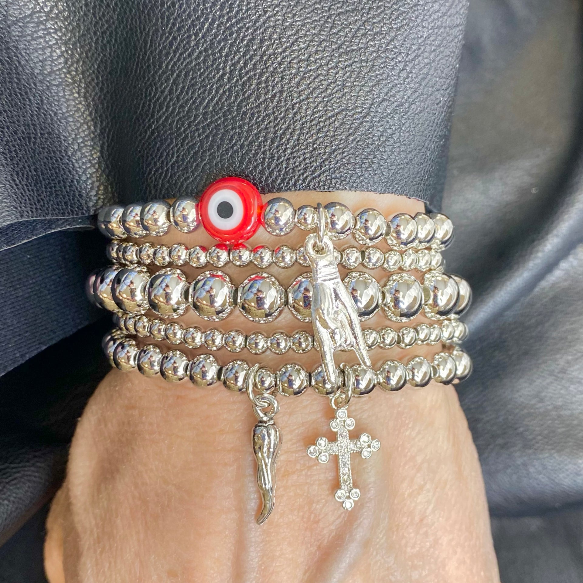 love lisa model wearing lucia cornicello cross bracelet silver beads italian horn charm and crystal cross stack bracelet