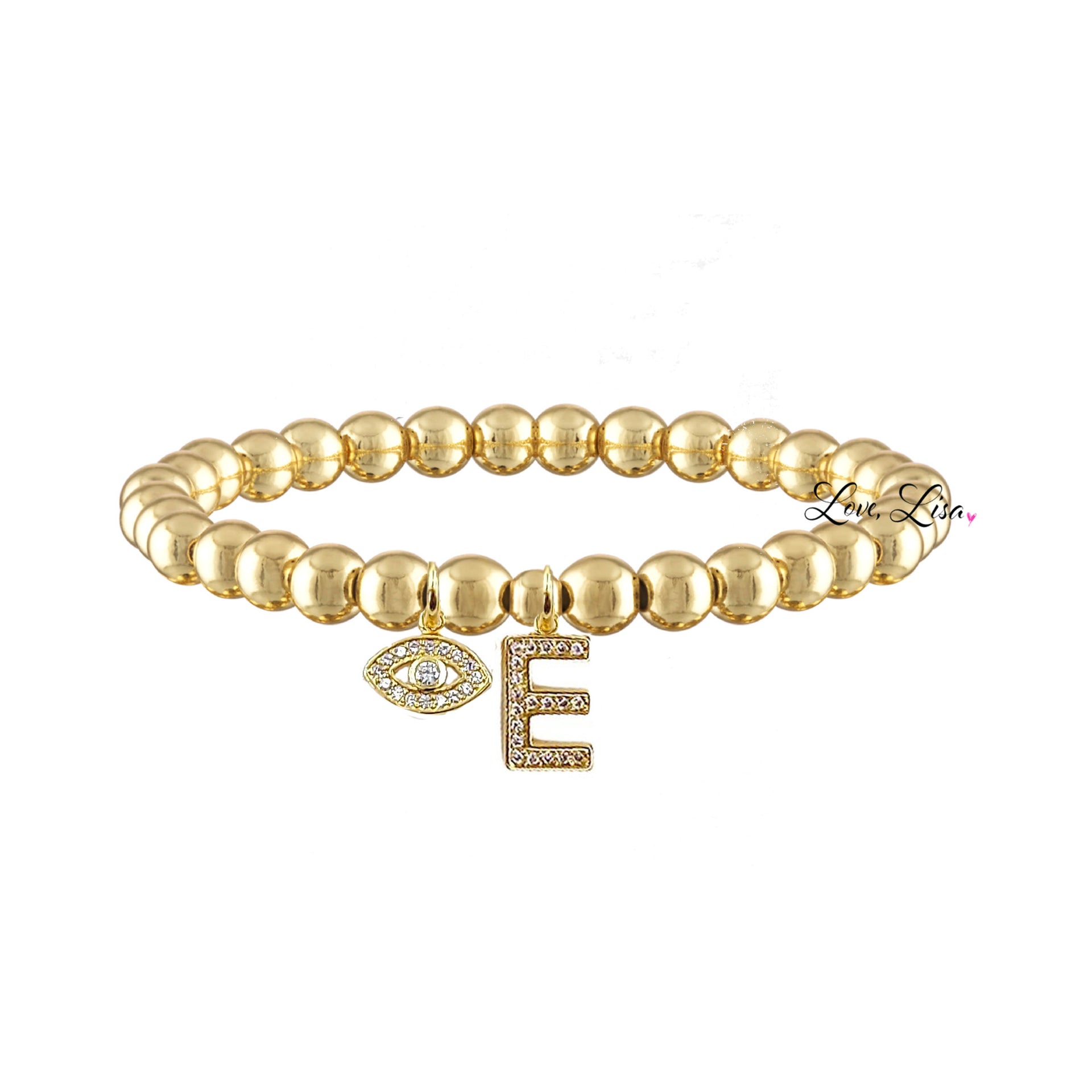 A gold-colored bracelet with a series of round beads and a letter 'M' with a sparkling stone on it.