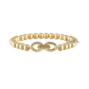 A gold-colored bracelet featuring a series of round beads and a decorative link in the center, on a white background.