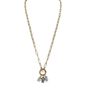 A gold-colored necklace with a lobster clasp, featuring a charm with a bear and the moon.